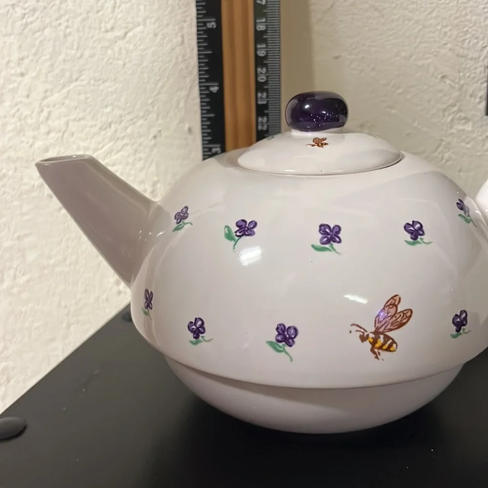 Small white teapot with violet and bee details.